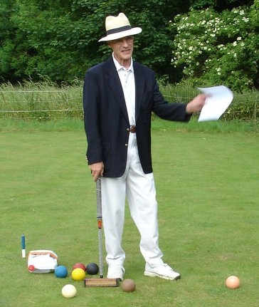 A gent playing croquet on the lawn